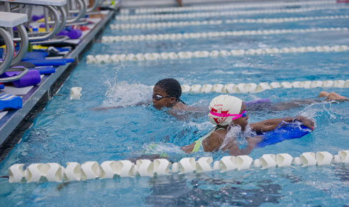 Jamovia Womack (right) uses a kickboard as she swims laps with Isaam Bradley during practice for the City of Atlanta Dolphins at Adamsville Natatorium on Tuesday, May 28, 2013.