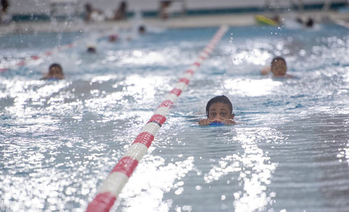 Sanaa Hardy (center) holds onto a kickboard as she swims laps during practice for the City of Atlanta Dolphins at Adamsville Natatorium on Tuesday, May 28, 2013. 