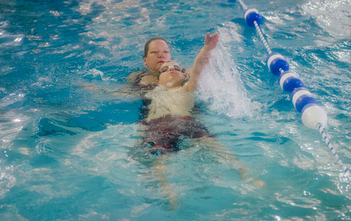 Tracey Wehunt (left) helps Kai Norton practice his backstroke during H2O Zone Camp at SeaVentures in Alpharetta on Thursday, June 6, 2013.