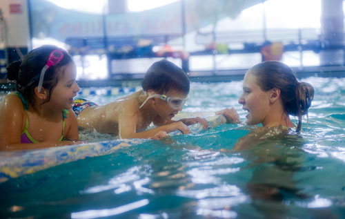 Lizzy Rincon (left) and Ashton Copeland learn to swim with the help of instructor Victoria Walker during H2O Zone Camp at SeaVentures in Alpharetta on Thursday, June 6, 2013. 