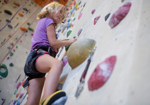 Kate Dabson looks for her next hold as she makes her way up a rock wall during climbing camp at the Stone Summit Climbing Center in Atlanta on Thursday, June 6, 2013. 