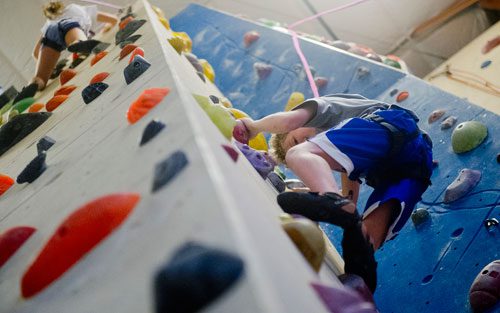 Phoenix Diacon (right) makes his way up a rock wall as Emma Delman nears the top during climbing camp at the Stone Summit Climbing Center in Atlanta on Thursday, June 6, 2013. 