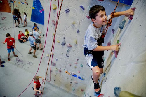 Aiden Levy (right) makes his way up a rock wall during climbing camp at the Stone Summit Climbing Center in Atlanta on Thursday, June 6, 2013.