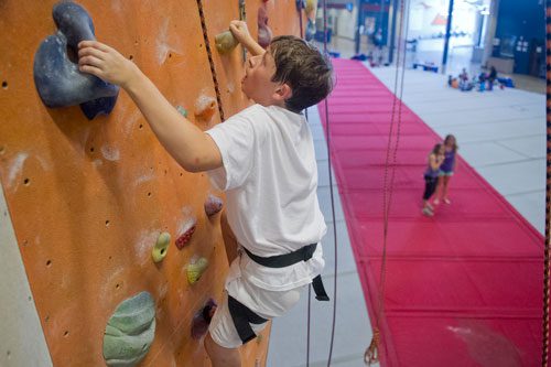 Stephen Hughes makes his way up a rock wall during climbing camp at the Stone Summit Climbing Center in Atlanta on Thursday, June 6, 2013. 