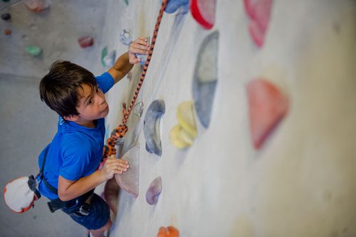 Ben Singer pulls himself up a rock wall during climbing camp at the Stone Summit Climbing Center in Atlanta on Thursday, June 6, 2013. 