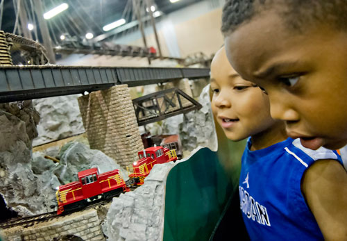 Dontae Chambers (left) and Trey Neal watch HO scale trains run down the tracks of the Atlanta Interlocking Model Railroaders' display during the 23rd Annual National Train Show at the Cobb Galleria Centre in Atlanta on Saturday, July 20, 2013. 