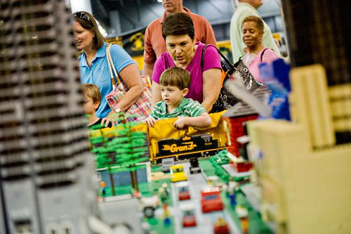 Blake Cutler (center) and Sylvia Leland watch a train pass as they look at the North Georgia LEGO Train Club's display during the 23rd Annual Nation Train Show at the Cobb Galleria Centre in Atlanta on Saturday, July 20, 2013. 