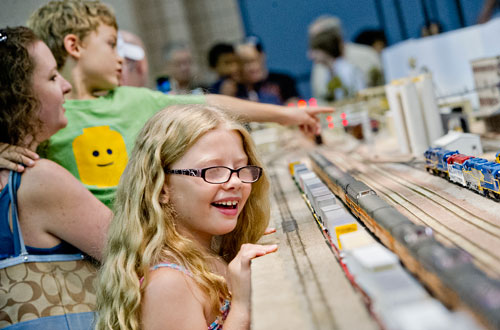 Morgan Pritchard (right), her mother Jessica and brother Evan watch a train pass as they look at the Gulf Western Model Railroad Society's display during the 23rd Annual Nation Train Show at the Cobb Galleria Centre in Atlanta on Saturday, July 20, 2013. 