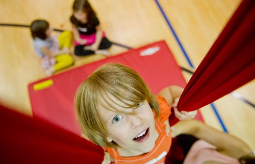 Susan Price (center) hangs from silks during Circus Summer Camp at Davis Academy in Dunwoody on Wednesday, July 10, 2013. 