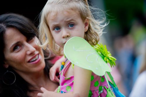 Kaitlyn Brindley (right) is held by her mother Liza as they take part in the festivities at the Chattahoochee Nature Center in Roswell during the 14th annual Flying Colors Butterfly Festival on Saturday, July 13, 2013.