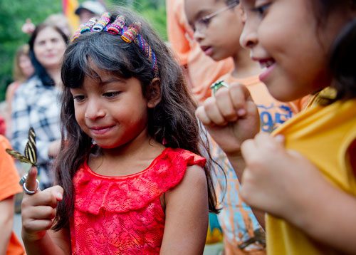 Abbie Hendricks (left) holds a butterfly on her finger as she stands next to Ethan Hague and Holly Pierce at the Chattahoochee Nature Center in Roswell during the 14th annual Flying Colors Butterfly Festival on Saturday, July 13, 2013.