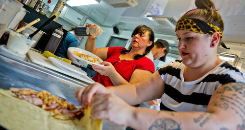 Giovanna Rosenfeld (left) and Kara Hornbuckle prepare crepes inside the A Movable Feast truck during the Atlanta Street Food Festival at Piedmont Park on Saturday, July 13, 2013. 