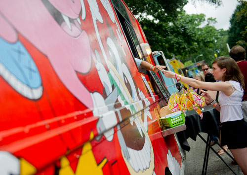 Danielle Pelton hands over money after ordering food from the Wonderlicious on Wheels truck during the Atlanta Street Food Festival at Piedmont Park on Saturday, July 13, 2013. 