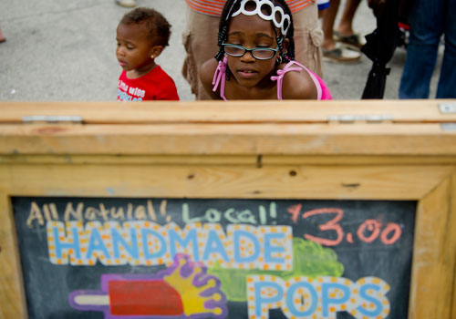 Alaina James (right) looks at the menu for King of Pops as she stands next to her sister Amya during the Atlanta Street Food Festival at Piedmont Park on Saturday, July 13, 2013. 