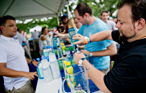 Jay Irby (right) and Toby Butler pour gin into glasses under the direction of Ivaylo Donchev during the Atlanta Street Food Festival at Piedmont Park on Saturday, July 13, 2013. 