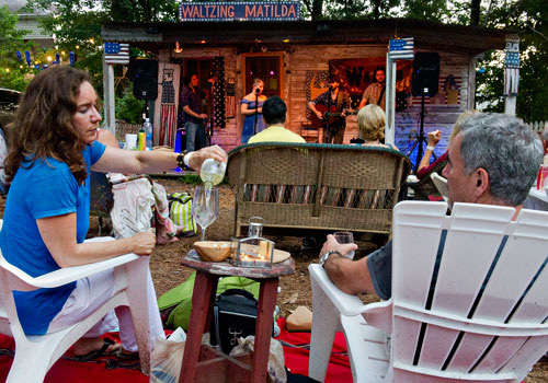 Kathryn King (left) pours a glass of wine as she next to her husband Dan while they listen to the band Waller perform on stage at Matilda's Under the Pines in Alpharetta on Saturday, July 13, 2013. 