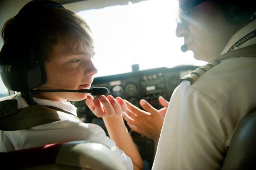 Rob Trotter (left) talks to the air traffic control tower at Dekalb-Peachtree Airport as he flies a single engine Cessna Skyhawk with the help of Captain Rohan Bhatia during aviation camp on Saturday, June 15, 2013. 