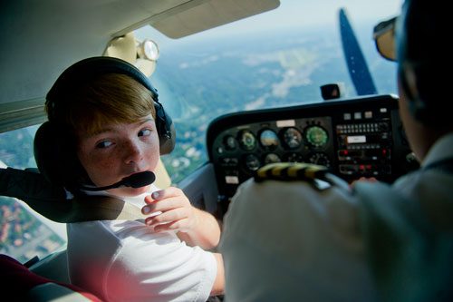Rob Trotter (left) glances behind him as he flies a single engine Cessna Skyhawk over Atlanta with the help of Captain Rohan Bhatia during aviation camp on Saturday, June 15, 2013. 
