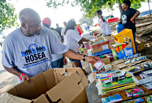 Andre Shockley (left) unpacks the last of the school supplies before the start of the Hosea Feed the Hungry & Homeless' 8th Annual Back to School Jamboree at Turner Field's Blue Lot in Atlanta on Saturday, July 20, 2013. 
