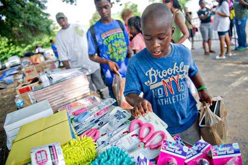 Joshua Blakely (right) and his older brother Damien pick out some extra school supplies during the Hosea Feed the Hungry & Homeless' 8th Annual Back to School Jamboree at Turner Field's Blue Lot in Atlanta on Saturday, July 20, 2013. 