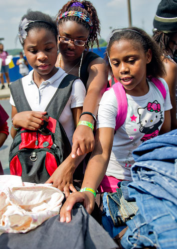 Dominique Williams (left), Kanice Reid and Melanie Scott pick out clothes during the Hosea Feed the Hungry & Homeless' 8th Annual Back to School Jamboree at Turner Field's Blue Lot in Atlanta on Saturday, July 20, 2013.