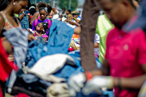 Skye Njoroge (left) and Nia Gill pick out clothes during the Hosea Feed the Hungry & Homeless' 8th Annual Back to School Jamboree at Turner Field's Blue Lot in Atlanta on Saturday, July 20, 2013. 