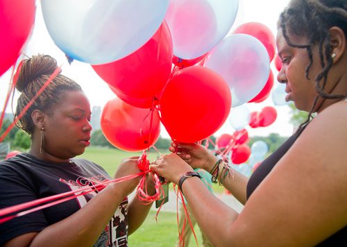 LaDie Mansfield (left) and Shapel LaBorde prepare balloons for the moment of silence during the We Are Here Rally for Respect in Rememberance of Teresa Weaver Pickard at Piedmont Park in Atlanta on Wednesday, June 26, 2013. 