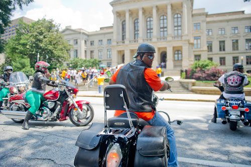 Charles Brooks (center) parks his bike on Washington Street in front of the capitol building during the Trayvon Martin Rally at the Georgia State Capitol in Atlanta on Sunday, July 28, 2013. 