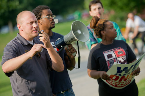 Ben Speight (left), co-chair for Atlanta Jobs with Justice, speaks during the We Are Here Rally for Respect in Rememberance of Teresa Weaver Pickard at Piedmont Park in Atlanta on Wednesday, June 26, 2013. 