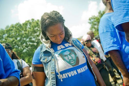Katrina Alexander bows her head in prayer during the Trayvon Martin Rally at the Georgia State Capitol in Atlanta on Sunday, July 28, 2013. 