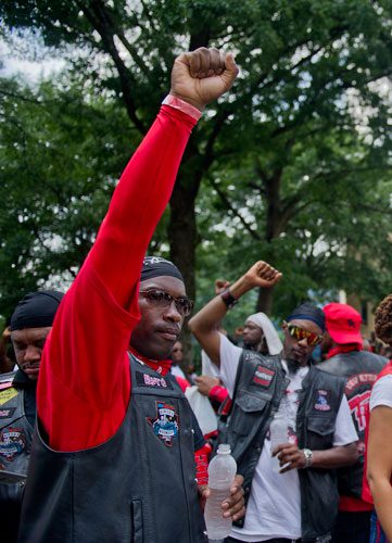 T.J. Jackman (center) and Reginald McCrary raise their hands in support during the Trayvon Martin Rally at the Georgia State Capitol in Atlanta on Sunday, July 28, 2013. 