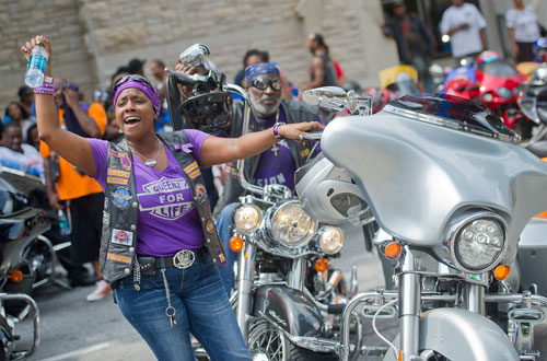 Shuntan Davis (left) cheers as she and Rudolph Long rev the engines on their motorcycles during the Trayvon Martin Rally at the Georgia State Capitol in Atlanta on Sunday, July 28, 2013. 