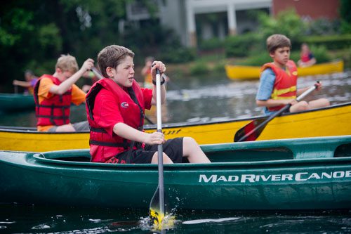 Jake Smith (center) paddles his canoe alongside Jacob Evans (left) and Ethan Grimes (right) on one of the three ponds at the Chattahoochee Nature Center in Roswell during Camp Kingfisher on Wednesday, June 5, 2013.