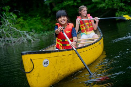 Celina Speir (left) and Dakota Pasley manuever their canoe on one of the three ponds at the Chattahoochee Nature Center in Roswell during Camp Kingfisher on Wednesday, June 5, 2013.