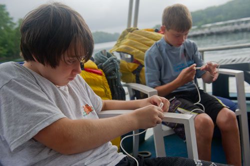 Jack Tilinksi (left) and Alex Foster practice tieing bowlin and stopper knots during Lord Nelson Charters' Summer Sailing Camp at Lake Lanier in Buford on Tuesday, July 9, 2013.
