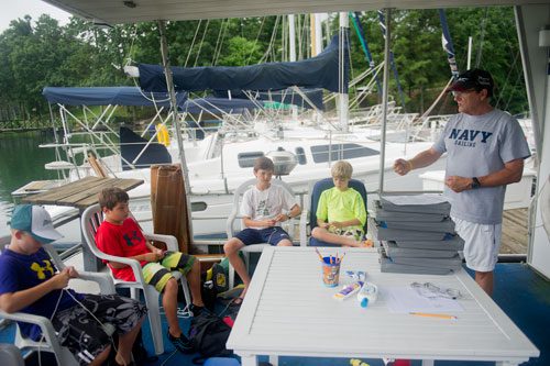 Instructor Tom Tilinski (right) talks to campers during Lord Nelson Charters' Summer Sailing Camp at Lake Lanier in Buford on Tuesday, July 9, 2013.