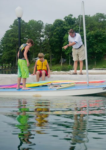 Chase Hart (left) and Parks Barnard get help from Terry Lee as they get their boat ready to sail during Lord Nelson Charters' Summer Sailing Camp at Lake Lanier in Buford on Tuesday, July 9, 2013.