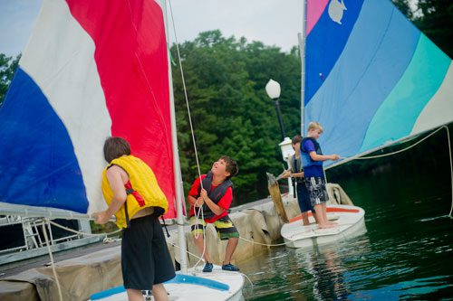 Paul Fiorillo (center), Jack Tilinski (left), Max White and Jake Sibbitt (right) rig the sails on their boats during Lord Nelson Charters' Summer Sailing Camp at Lake Lanier in Buford on Tuesday, July 9, 2013. 