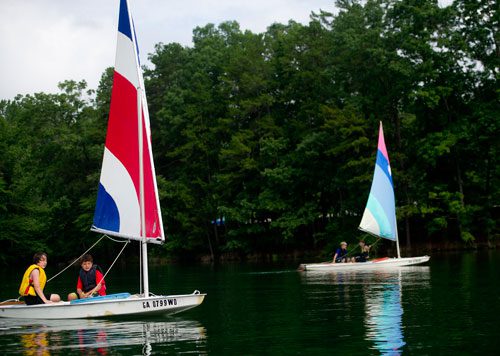 Jack Tilinski (left) and Paul Fiorillo catch the wind as they try to sail their sunfish sailboat across Lake Lanier past Jake Sibbitt and Max White during Lord Nelson Charters' Summer Sailing Camp in Buford on Tuesday, July 9, 2013. 