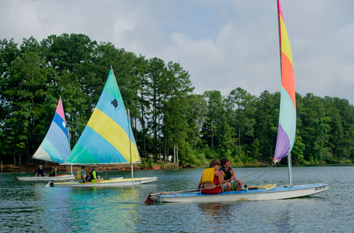 Chase Hart (right) and Parks Barnard sail their sunfish sailboat across Lake Lanier past other campers during Lord Nelson Charters' Summer Sailing Camp in Buford on Tuesday, July 9, 2013. 