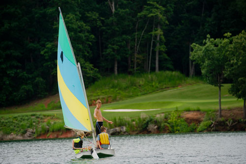 Austin Chastain (left) and Alex Foster (right) listen to directions from Christian Hagen as they sail their sunfish sailboat across Lake Lanier during Lord Nelson Charters' Summer Sailing Camp in Buford on Tuesday, July 9, 2013. 