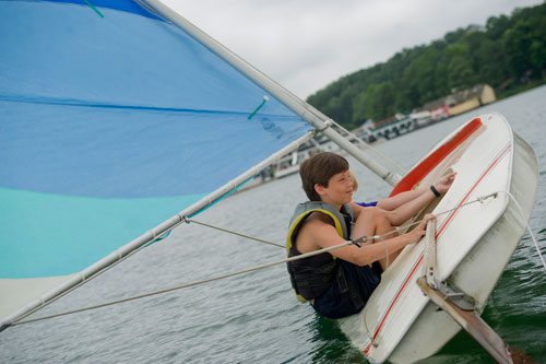 Max White (left) keep their boat from capsizing as they sail their sunfish sailboat across Lake Lanier during Lord Nelson Charters' Summer Sailing Camp in Buford on Tuesday, July 9, 2013. 