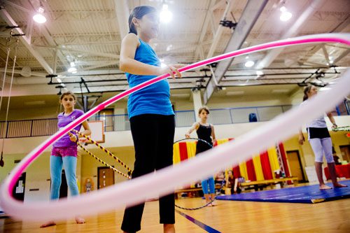 Ariel Scher (center) practices her hoop performance routine with her sister Sophia (right) and Katarina Gurevich during Circus Summer Camp at Davis Academy in Dunwoody on Wednesday, July 10, 2013.