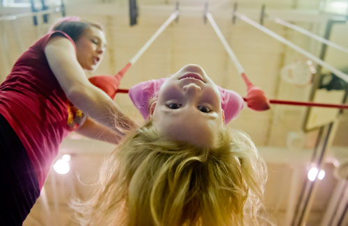 Amanda North (right) hangs from a triple trapeze as instructor Liz Ramsay helps steady her during Circus Summer Camp at Davis Academy in Dunwoody on Wednesday, July 10, 2013. 