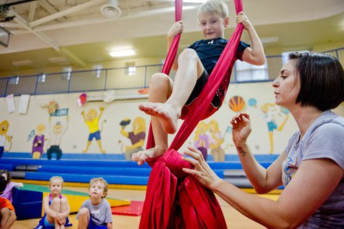 Instructor Katie Martin (right) teaches Spencer Burdett to use silks during Circus Summer Camp at Davis Academy in Dunwoody on Wednesday, July 10, 2013. 
