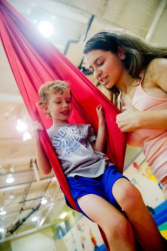 Thomas Preter (left) gets help from junior counselor Allie Goodman as he learns to use silks during Circus Summer Camp at Davis Academy in Dunwoody on Wednesday, July 10, 2013.