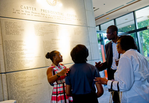 Dikembe Mutombo (center) speaks with his wife Rose (left), Tiffani Alexander and her mother Inetta before the start of America's Sunday Supper at the Carter Center in Atlanta on Sunday, August 11, 2013. 