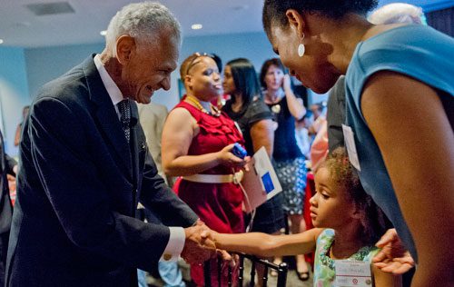 Rev. C.T. Vivian (left) shakes hands with Zoe Shields and her mother Monique Terry during America's Sunday Supper at the Carter Center in Atlanta on Sunday, August 11, 2013. 