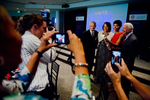 Former President Jimmy Carter (right), Laysha Ward, Rev. Bernice King and Rev. C.T. Vivian are surrounded by photographers as they pose for a photo during America's Sunday Supper at the Carter Center in Atlanta on Sunday, August 11, 2013. 