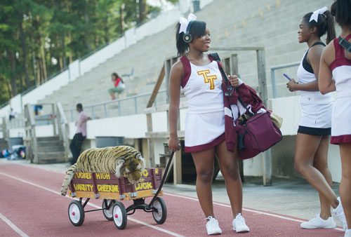 Tucker's Alexsis Thornton (center) talks with Jasmine Toombs as she pulls a wagon with the Tigers mascot before their game against Cedar Grove at Panthersville Stadium in Decatur on Friday, August 23, 2013.   
